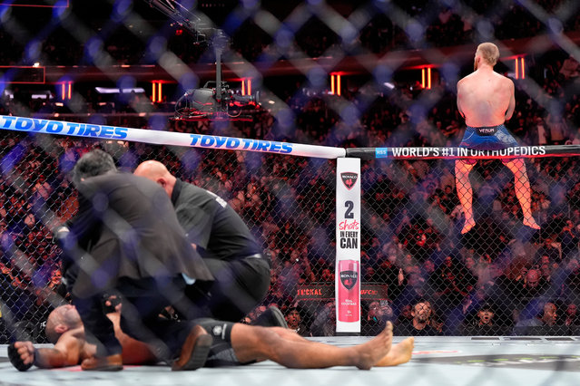 Bo Nickal sits on a cage railing celebrating his third-round knockout of Rodolfo Vieira at the UFC 322 mixed martial arts event, in New York, November 15, 2025. (Photo by Yuki Iwamura/AP Photo)