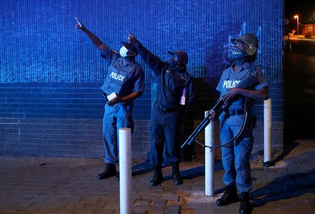Police officers gesture during a patrol on New Year's day as a nighttime curfew is reimposed in Johannesburg, South Africa on January 1, 2021. (Photo by Siphiwe Sibeko/Reuters)
