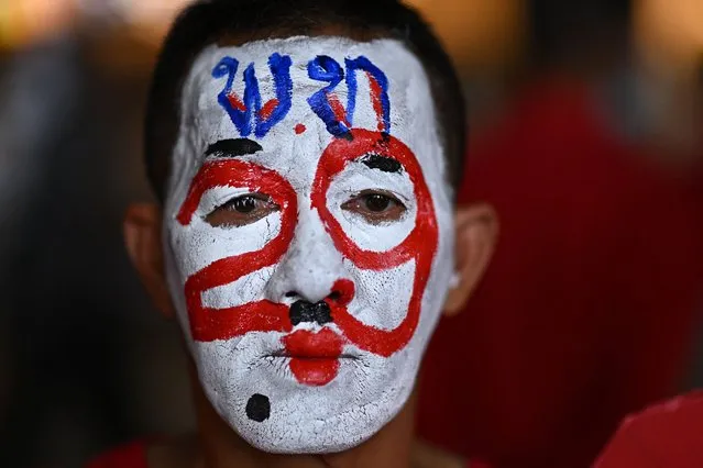 A supporter wearing face paint with the election number of Pheu Thai Party's prime ministerial candidate Paetongtarn Shinawatra attends the party's final major campaign event in Bangkok on May 12, 2023, ahead of Thailand's May 14 general election. (Photo by Manan Vatsyayana/AFP Photo)