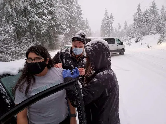 Josephine County Public Health staff and volunteers administer COVID-19 vaccinations to stranded motorists after returning from a clinic with unused doses and getting stuck in a snowstorm on Highway 199 in Hayes Hill, Oregon, January 26, 2021. (Photo by Josephine County Public Health/via Reuters)