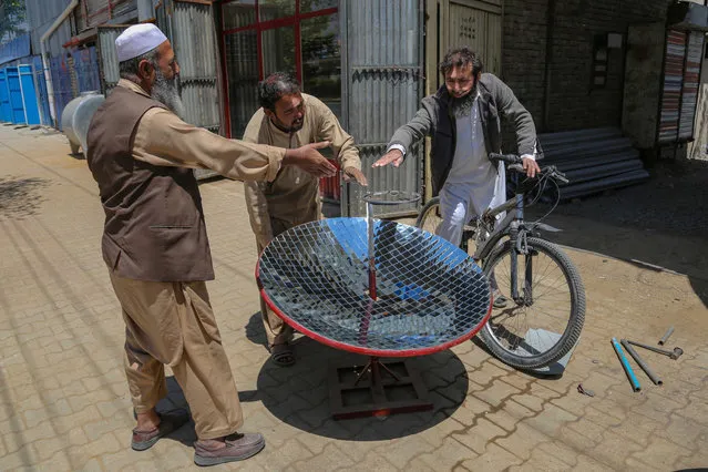 Ghulam Abbas (C), a local blacksmith tests a Solar Cooker he manufactures at his workshop in Kabul, Afghanistan, 08 May 2023. (Photo by Samiullah Popal/EPA/EFE)