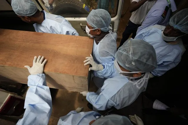 Healthcare workers carry the body of a person who died in Friday's train accident in Balasore, into an ambulance at the All India Institute of Medical Sciences hospital in Bhubaneswar in the eastern state of Orissa, India, Monday, June 5, 2023. (Photo by Rafiq Maqbool/AP Photo)