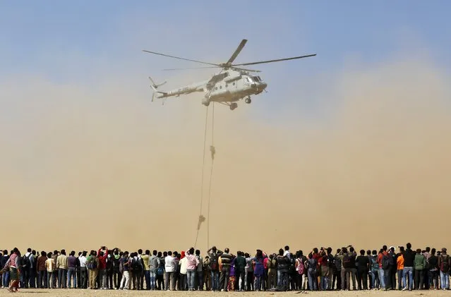 Spectators watch Indian Air Force (IAF) soldiers performing during an awareness drive in the western Indian city of Ahmedabad, January 17, 2015. The drive is aimed at motivating young people to join the Indian armed forces. (Photo by Amit Dave/Reuters)