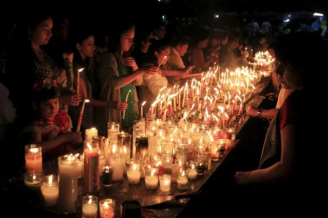 Devotees light candles to celebrate the Day of the Virgin of Guadalupe outside the Basilica of Guadalupe in San Salvador, El Salvador December 12, 2015. (Photo by Jose Cabezas/Reuters)