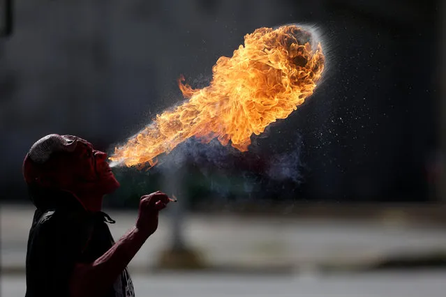 A street performer wearing a devil mask spits fire in Monterrey, Mexico, October 31, 2016. (Photo by Daniel Becerril/Reuters)