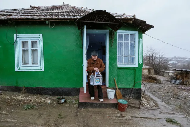 A member of a local election commission carries a portable ballot box as he leaves a house of local resident during a presidential election in the village of Suruceni, outside Chisinau, Moldova, November 13, 2016. (Photo by Gleb Garanich/Reuters)