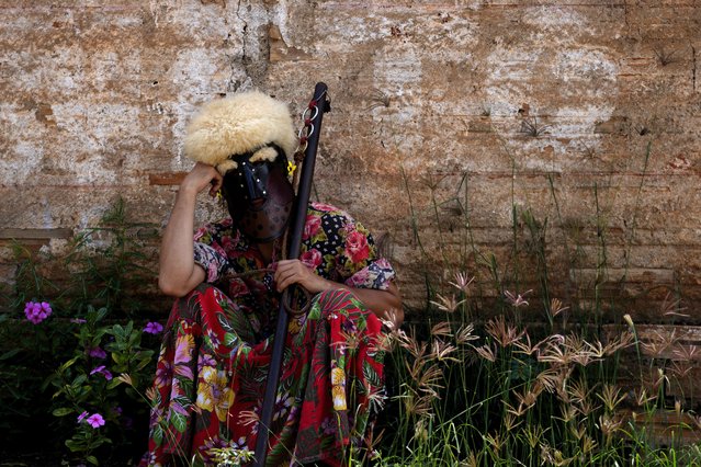 A performer dressed as Bastiao the clown rests amid performing with the Santo Antonio Folia de Reis group during a procession marking Epiphany, or Three Kings Day, in Santo Antonio de Goias, Brazil, Sunday, January 5, 2025. (Photo by Eraldo Peres/AP Photo)