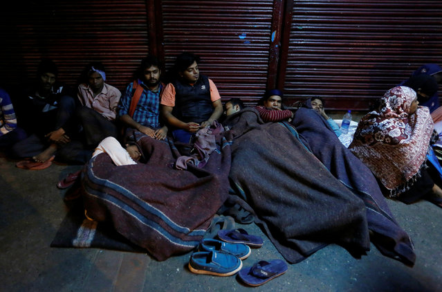 People sleep outside a bank as they wait for the bank to open to exchange their old high denomination bank notes in the early hours, in the old quarters of Delhi, India, November 16, 2016. (Photo by Adnan Abidi/Reuters)