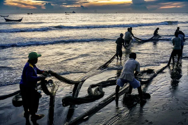 Fishermen pull a net at sunrise on the coast of Hagu Village in Lhokseumawe June 7, 2023. (Photo by Azwar Ipank/AFP Photo)