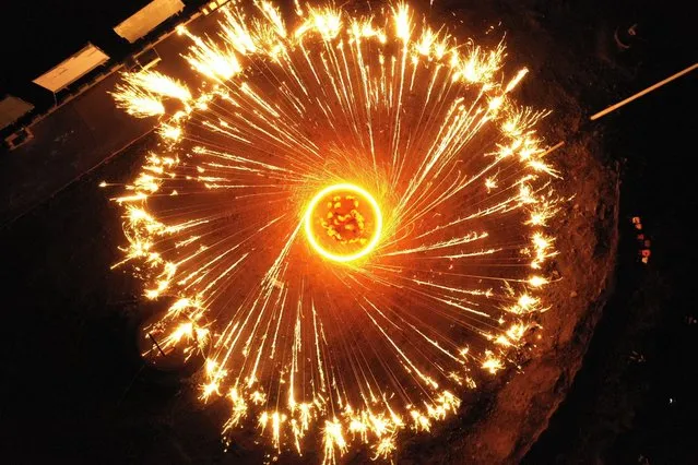 Sparks pour down as folk artists spray burning iron chips to shower sparks-like fireworks in Luanping County, north China's Hebei Province, 05 July 2023. (Photo by Mu Yu/Xinhua News Agency/EPA)