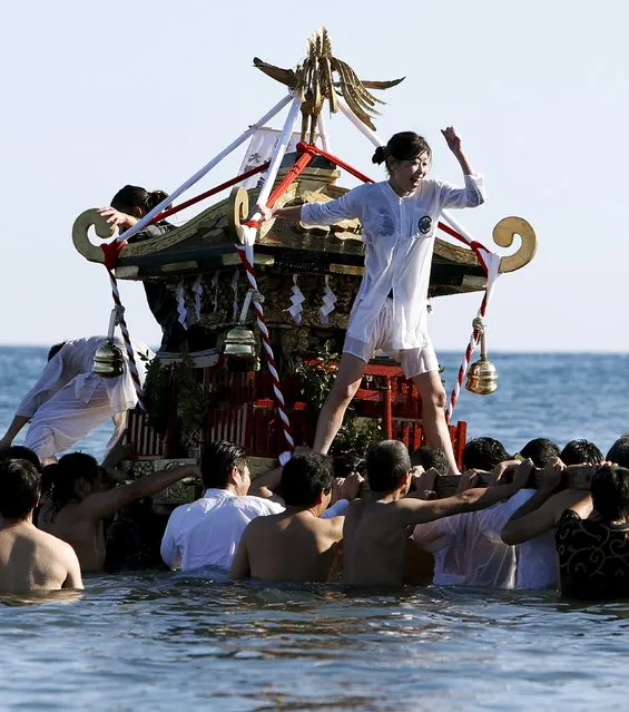 A woman riding on a “mikoshi” or portable shrine cheers on people as they carry it into the sea during a festival to wish for calm waters in the ocean and good fortune in the new year in Oiso, Kanagawa prefecture, west of Tokyo, Japan, January 1, 2016. (Photo by Yuya Shino/Reuters)