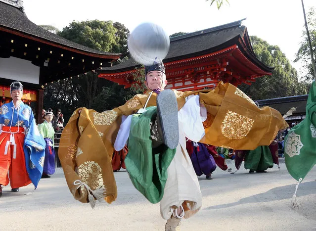 Wearing ancient Japanese costumes, members of the Kemari Preservation Society play "kemari," an ancient Japanese ball-lifting game using only the right leg, at the Shimogamo shrine in Kyoto, western Japan on January 4, 2016. The annual New Year football-like game came from China almost 1,400 years ago. (Photo by AFP Photo/JIJI Press)