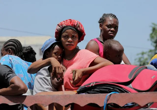 People sit on a truck as they are fleeing their neighbourhood Carrefour Feuilles after gangs took over, in Port-au-Prince, Haiti on August 15, 2023. (Photo by Ralph Tedy Erol/Reuters)
