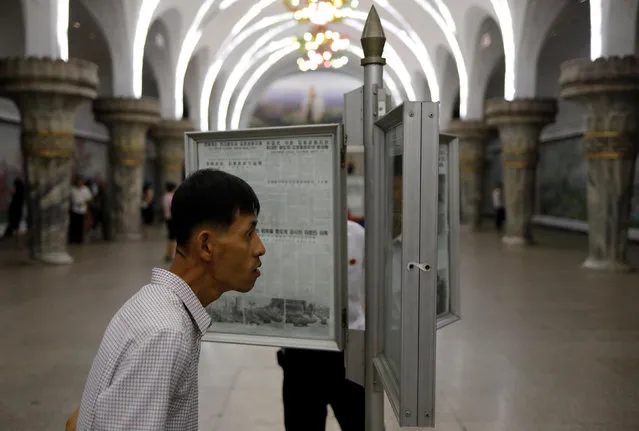 Commuters read newspapers displayed at a subway station in Pyongyang, North Korea on September 11, 2018. (Photo by Danish Siddiqui/Reuters)