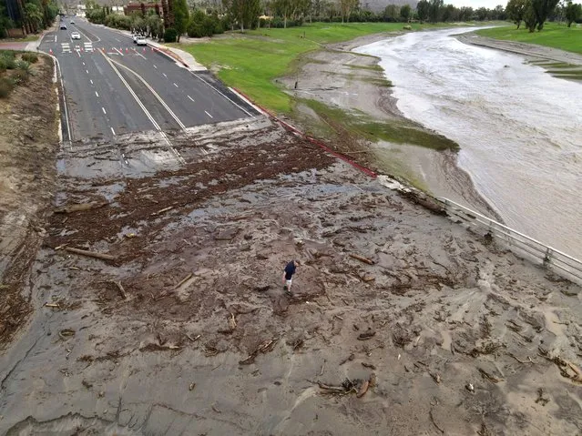 An aerial image shows a man surveying debris following heavy rains from Tropical Storm Hilary, at Thurderbird Country Club in Rancho Mirage, California, on August 21, 2023. Tropical Storm Hilary drenched Southern California with record rainfall, shutting down schools, roads and businesses before edging in on Nevada on August 21, 2023. California Governor Gavin Newsom had declared a state of emergency over much of the typically dry area, where flash flood warnings remained in effect until this morning. (Photo by David Swanson/AFP Photo)