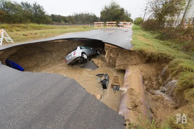 A handout image released 06 December 2016 by the San Antonio Fire Department showing submerged vehicles after reserve deputy Dora Linda (Solis) Nishihara was killed late 04 December when an underground pipe ruptured causing a sinkhole that collapsed a roadway swallowing two vehicles killing Nishihara and injuring a second driver who was rescued in San Antonio, Texas USA, 06 December 2016. (Photo by EPA/San Antonio Fire Department)