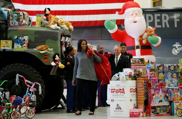 Carrying a sack full of toys, the U.S. First Lady Michelle Obama makes her annual visit to the Toys for Tots event at Joint Base Anacostia–Bolling in Washington, U.S. December 7, 2016. (Photo by Kevin Lamarque/Reuters)