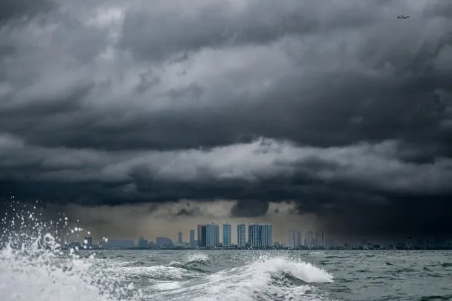 Thick clouds cover the Indonesia's capital sky as seen from northern Jakarta waters, on February 22, 2023. (Photo by Bay Ismoyo/AFP Photo)