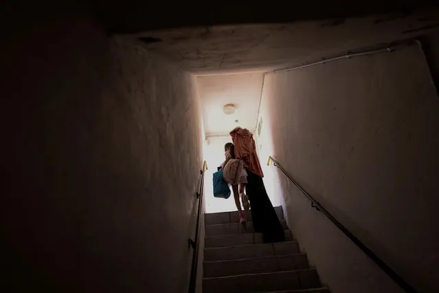 An Israeli girl carries her belongings as she walks out from a public bomb shelter back home, following Israel-Hamas truce, in Ashkelon, Israel on May 21, 2021. (Photo by Ronen Zvulun/Reuters)