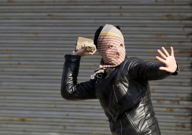 A Kashmiri Muslim demonstrator throws a stone towards Indian police (unseen) during a protest in Srinagar January 21, 2016. Clashes between Indian police and Kashmir Muslim demonstrators broke out on Thursday after a protest which was organised by the Jammu Kashmir Liberation Front (JKLF), a Kashmiri separatist party, to mark the anniversary of the killings of at around 50 people allegedly by Indian security forces during a protest on January 21, 1990, demonstrators said. (Photo by Danish Ismail/Reuters)