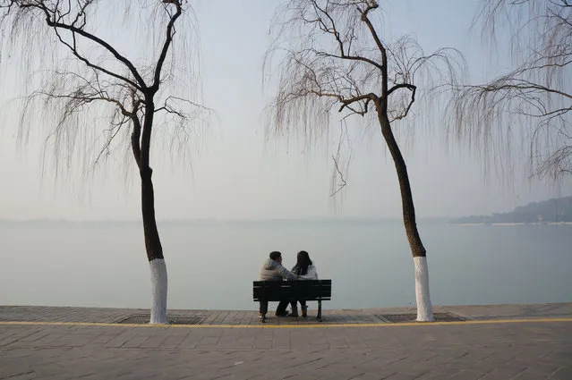 People sit on a bench at a park in heavy smog during a polluted day in Beijing, China, December 18, 2016. (Photo by Reuters/Stringer)