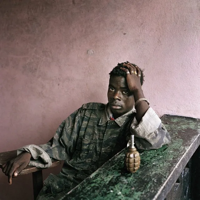 Young rebel fighter and hand grenade, Tubmanburg, Liberia, June 16, 2003. (Photo by Tim Hetherington/Magnum Photos)