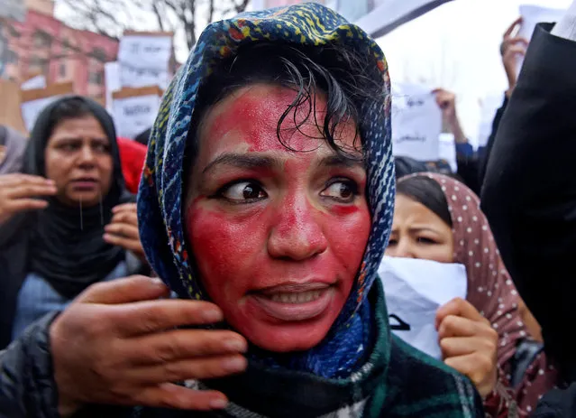 An Afghan protester, her face painted red to depict Farkhunda's bloodied face, shouts slogans with others during a rally in front of The Supreme Court in Kabul on March 24, 2015, held to protest the killing of Afghan woman Farkhunda. More than a thousand people protested in the Afghan capital, to call for justice after a woman was brutally killed by a mob who falsely accused her of burning a copy of the Koran. (Photo by Shah Marai/AFP Photo)