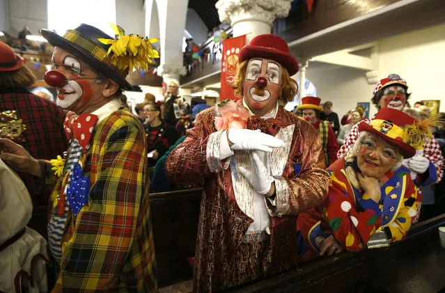 Clowns stand at the pews of the All Saints Church during the Grimaldi clown service in Dalston, north London, February 7, 2016. (Photo by Peter Nicholls/Reuters)