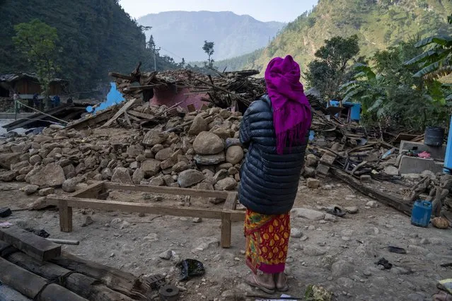 A survivor looks at her earthquake damaged house in Rukum District, northwestern Nepal, Monday, November 6, 2023. The Friday night earthquake in the mountains of northwest Nepal killed more than 150 people and left thousands homeless. (Photo by Niranjan Shrestha/AP Photo)