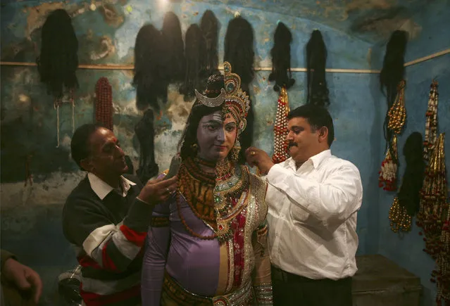 An artist is helped with getting dressed as both Hindu god Lord Shiva and his wife goddess Parvati before taking part in a religious procession ahead of the Mahashivratri festival in Jammu February 26, 2014. Hindus celebrate Mahashivratri, better known as Lord Shiva's wedding anniversar. (Photo by Mukesh Gupta/Reuters)