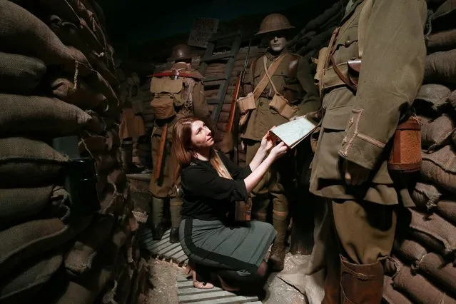 A member of staff poses next to British World War One soldiers in a recreated trench during a press preview for the “Remembering 1916 – Life on the Western Front” exhibition at Whitgift School on March 8, 2016 in Croydon, England. The exhibition presents 1916 and the First World War as seen by Britain, France and Germany and will run from March 12 to August 31 2016. (Photo by Carl Court/Getty Images)