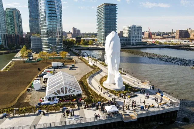 City officials and developers dedicated a permanent new sculpture titled “Water's Soul” on Thursday, October 21, 2021, in Jersey City, N.J. The 80-foot tall sculpture depicts a young woman with a finger on her lips shushing or calling for silence from the New York City skyline across the Hudson River. Artist Jaume Plensa from Barcelona, Spain, says he intends the sculpture to inspire silent contemplation. (Photo by Ted Shaffrey/AP Photo)