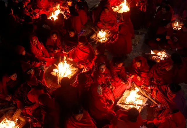 Hindu women sit around fires to keep warm before taking holy baths at Saali River during the Swasthani Brata Katha festival at Sankhu in Kathmandu, Nepal, January 12, 2017. (Photo by Navesh Chitrakar/Reuters)