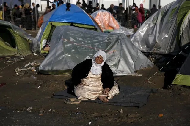 A refugee sits outside her tent at a makeshift camp for refugees and migrants at the Greek-Macedonian border near the village of Idomeni, Greece, March 19, 2016. (Photo by Alkis Konstantinidis/Reuters)