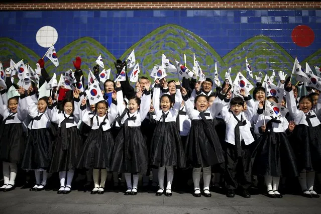 Children wearing a Korean traditional costume Hanbok wave South Korean national flags during a re-enactment of the Independence Movement Day in Seoul, South Korea, March 1, 2016. (Photo by Kim Hong-Ji/Reuters)