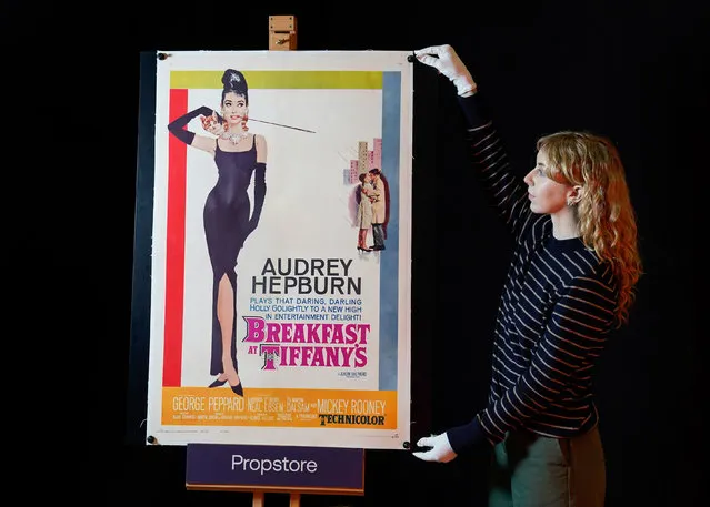 A Propstore employee adjusts a US one-sheet for the 1961 film “Breakfast at Tiffany's” (Estimate £5000 - £10,000) during a preview for the showbiz memorabilia auction, at the Propstore in Rickmansworth, Hertfordshire on Thursday, January 19, 2023. (Photo by Andrew Matthews/PA Images via Getty Images)