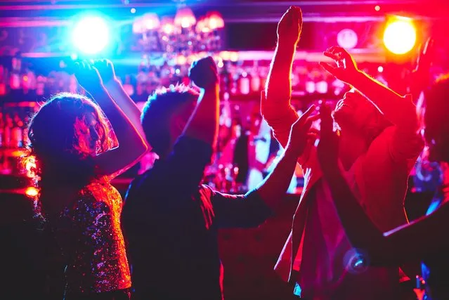 Group of dance lovers enjoying disco in nightclub. (Photo by Rex Features/Shutterstock)