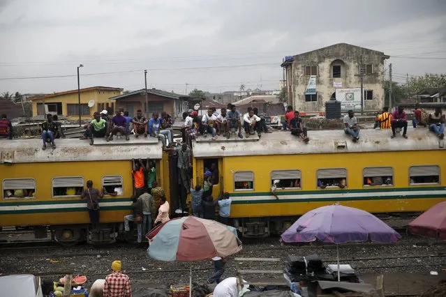 People sit atop a train in Agege district in Nigeria's commercial capital Lagos April 12, 2016. (Photo by Akintunde Akinleye/Reuters)