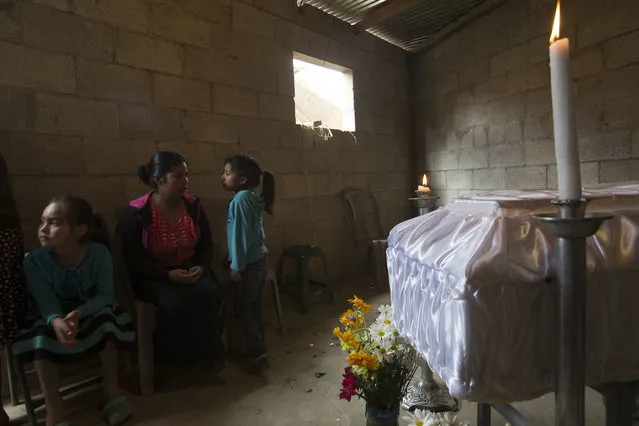 Relatives sit next to the coffin of 14-year-old Ana Roselia Perez Junay, who died in a fire at a children's shelter, inside her mother's home in Zaragoza, Guatemala, Sunday, March 12, 2017. The death toll in the March 8 fire rose to 40 on Sunday with the announcement that another girl has died of burns. (Photo by Moises Castillo/AP Photo)