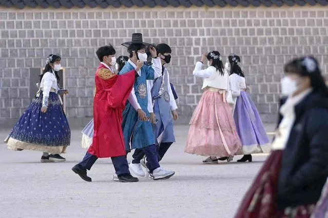 Visitors wearing face masks to help curb the spread of the coronavirus walk at the Gyeongbok Palace, in Seoul, South Korea, Friday, January 7, 2022. (Photo by Lee Jin-man/AP Photo)