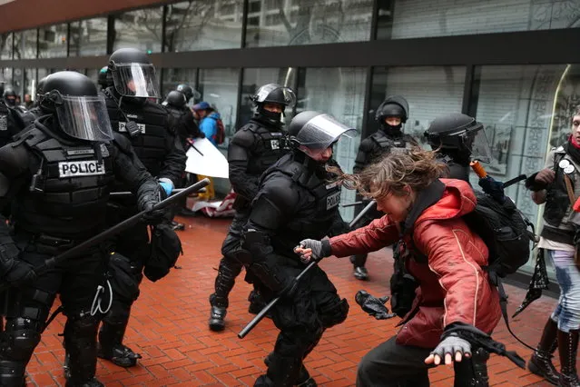 Protesters clash with police in Portland, Ore., on Monday, February 20, 2017. Thousands of demonstrators turned out Monday across the U.S. to challenge President Donald Trump in a Presidents Day protest dubbed “Not My President's Day”. (Photo by Dave Killen/The Oregonian via AP Photo)