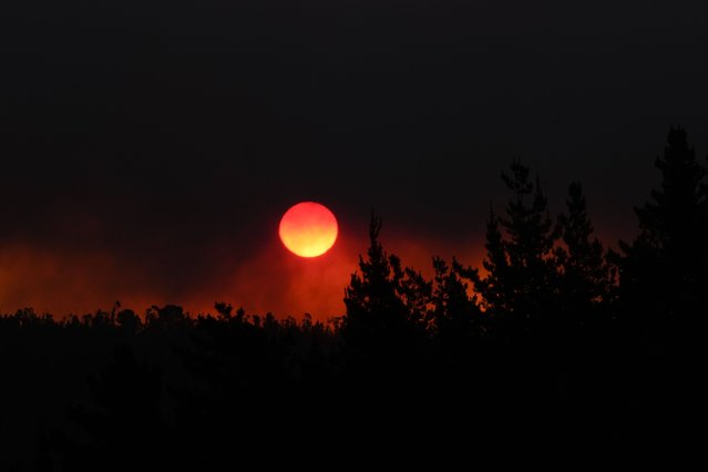 The sun sets as smoke fills the sky during a the forest fire encroaching on Vina del Mar, Chile, Saturday, February 3, 2024. (Photo by Esteban Felix/AP Photo)
