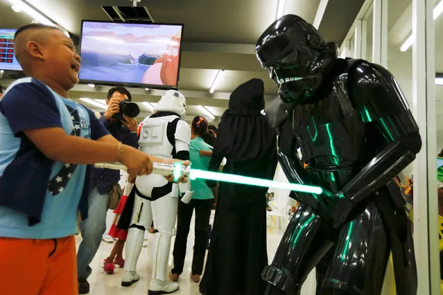 A member of a Star Wars fan club in Thailand, dressed as a Shadow stormtrooper plays with a boy during Star Wars Day celebration at the Queen Sirikit National Institute of Child Health in Bangkok, Thailand, May 4, 2016. (Photo by Chaiwat Subprasom/Reuters)