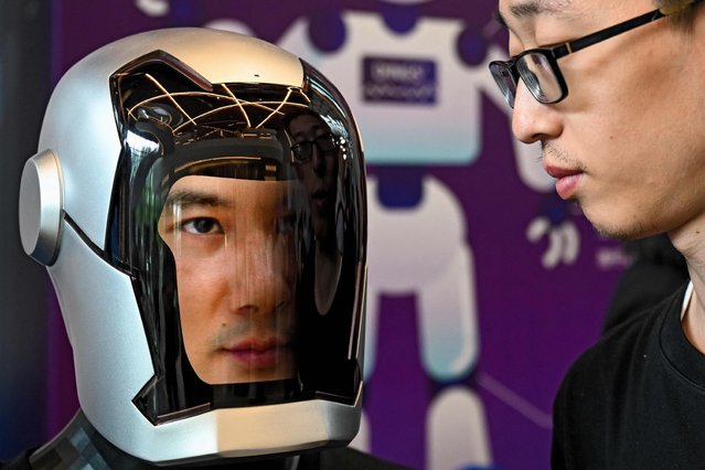 A visitor looks at a humanoid robot at the 2024 China Humanoid Robot Developers Conference in Shanghai on June 6, 2024. (Photo by AFP Photo/China Stringer Network)