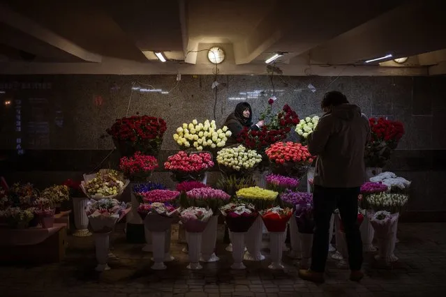 A woman prepares a bunch of flowers for a customer in downtown Kyiv, Ukraine, Monday, February 14, 2022. (Photo by Emilio Morenatti/AP Photo)