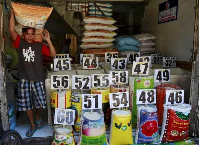 A worker carrying a sack of rice walks past a rice store in Manila, Philippines September 9, 2015. (Photo by Romeo Ranoco/Reuters)