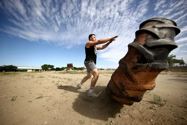  Olympic hopeful boxer Richard Torrez Jr. pushes a tractor tire over during a training session on June 06, 2020 in Tulare, California. Torrez Jr. was one of 13 boxers selected to represent Team USA at the Tokyo 2020 Olympic Games Boxing Qualifiers in Argentina, but the qualifier was canceled due to the coronavirus. The 20-year-old has won numerous international tournaments, and is currently ranked fifth in the world in the super heavyweight weight class. The training center in Colorado is currently closed so Torrez Jr. continues to train at home with his father, who is his coach. His father has implemented many different types of training methods, such as hitting cement rocks with a sledge hammer, filling up wheel barrels with sand, and flipping over tractor tires. Athletes across the globe are now training in isolation under strict policies in place due to the Covid-19 pandemic. (Photo by Ezra Shaw/Getty Images)