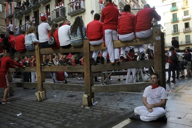 Revellers in traditional dress await the fourth running of the bulls on Estafeta corner at the San Fermin festival in Pamplona, northern Spain, July 10, 2015. (Photo by Eloy Alonso/Reuters)