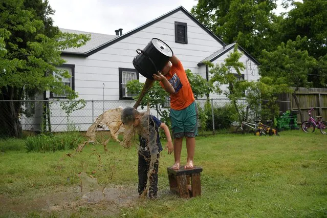 Jesus, son of Irma Rivera, an asylum-seeker from Honduras, plays after a rainstorm with his cousin Marcos outside the family home in Fort Worth, Texas, U.S., May 11, 2019. (Photo by Loren Elliott/Reuters)