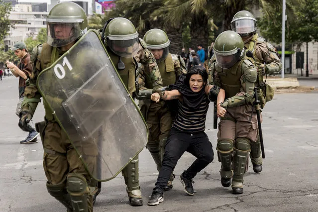 Carabineros apprehend a demonstrator during a protest against the rise in metro fares near Plaza Italia on October 19, 2019 in Santiago, Chile. The President of Chile Sebastián Piñera has declared the state of emergency in the Chilean capital as violence escalates due to protests triggered against the rising costs of living. (Photo by Agencia Makro/Getty Images)